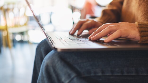 Nahaufnahme einer Frau, die auf einem Laptop arbeitet und tippt