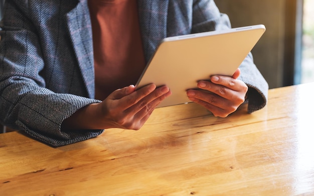 Nahaufnahme einer Frau, die ein digitales Tablet hält und verwendet