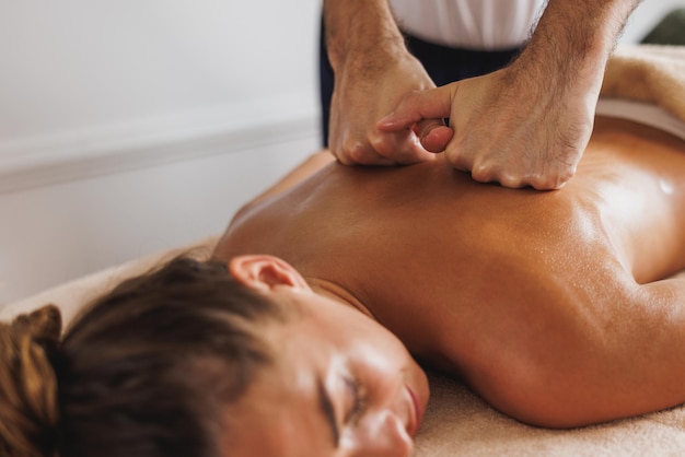 Nahaufnahme einer Frau, die eine entspannende Rückenmassage im Kosmetik-Spa-Center genießt.