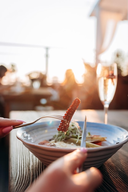 Nahaufnahme einer Frau, die köstlichen gegrillten Oktopus im Fischrestaurant isst Delikatesse und gesunde Gourmetküche