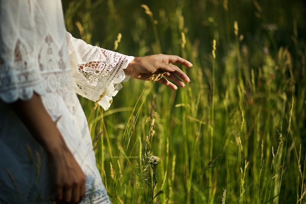 Nahaufnahme einer Frau, die mit der Hand Weizenspitzen berührt?