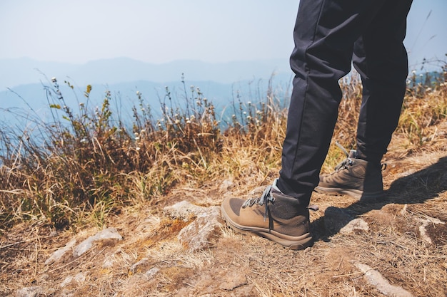 Nahaufnahme einer Frau, die mit Trekkingschuhen auf dem Gipfel des Berges wandert