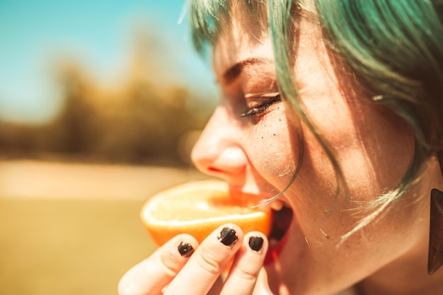 Nahaufnahme einer Frau, die Orangenfrüchte isst