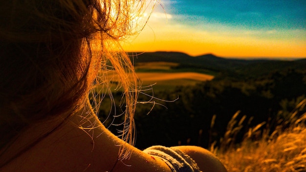 Nahaufnahme einer Frau gegen den Himmel bei Sonnenuntergang