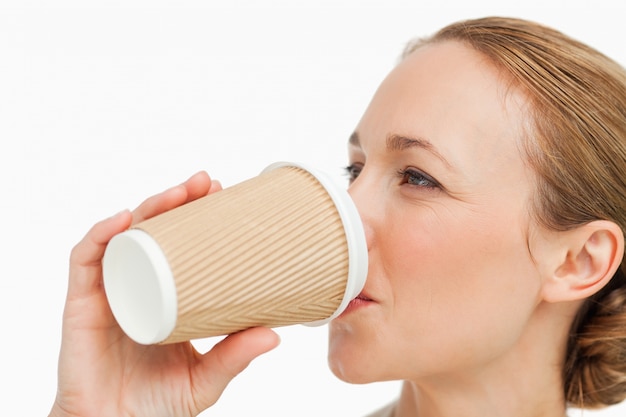 Nahaufnahme einer Frau in einer Klage einen Mitnehmerkaffee trinkend