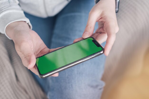 Nahaufnahme einer Frau mit Chromenschlüssel, die auf einer Couch sitzt