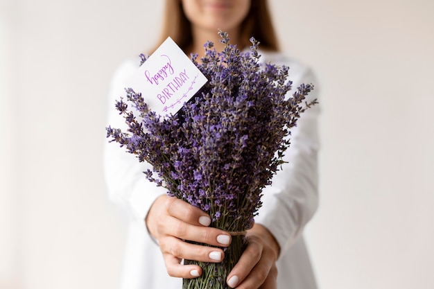 Nahaufnahme einer Frau mit einem Geburtstags-Lavendel-Bouquet