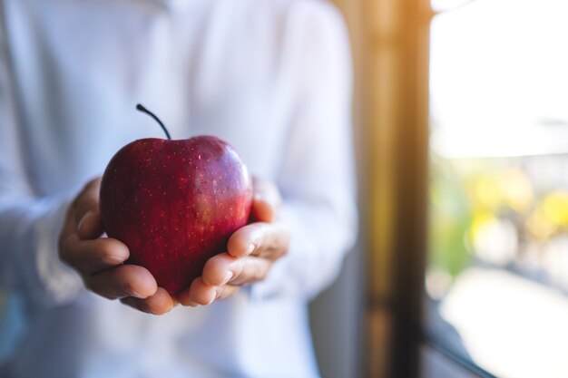 Nahaufnahme einer Frau mit einem roten Apfel