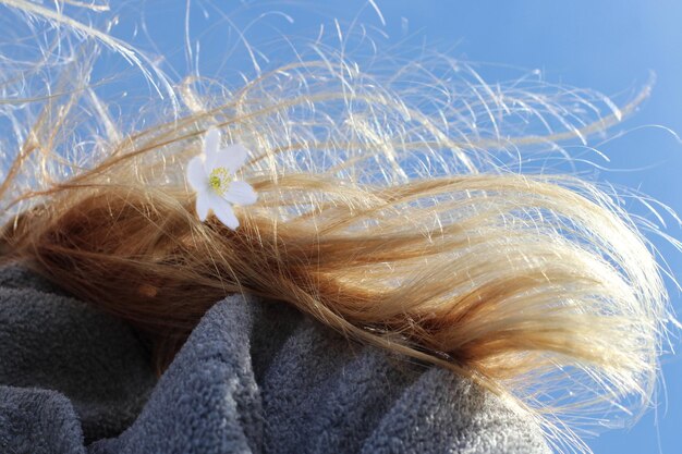 Nahaufnahme einer Frau mit einer Blume im Haar