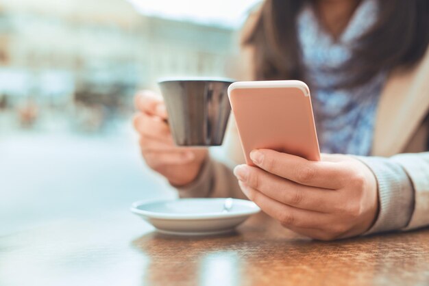 Nahaufnahme einer Frau mit Handy in einem Café