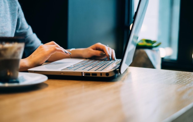Nahaufnahme einer Frau mit Laptop auf dem Tisch