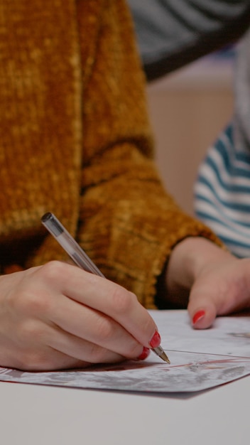 Nahaufnahme einer Frau mit Stift und Unterzeichnung der Weihnachtskarte für die Winterfeier. Paare, die festliche Postkarte an Heiligabend schreiben, die sich auf Feiertagsfeierlichkeiten mit Verwandten und Freunden vorbereiten.