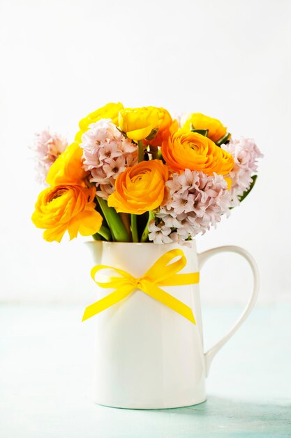 Nahaufnahme einer gelben Blumenvase vor weißem Hintergrund