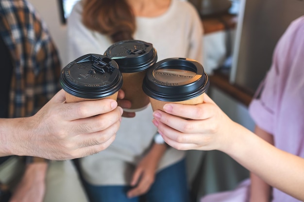 Nahaufnahme einer Gruppe junger Leute, die gerne zusammen im Café Kaffeetassen tranken und klirrten