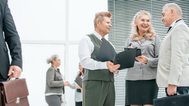 Nahaufnahme einer Gruppe von Mitarbeitern, die Dokumente besprechen, die im Büro stehen