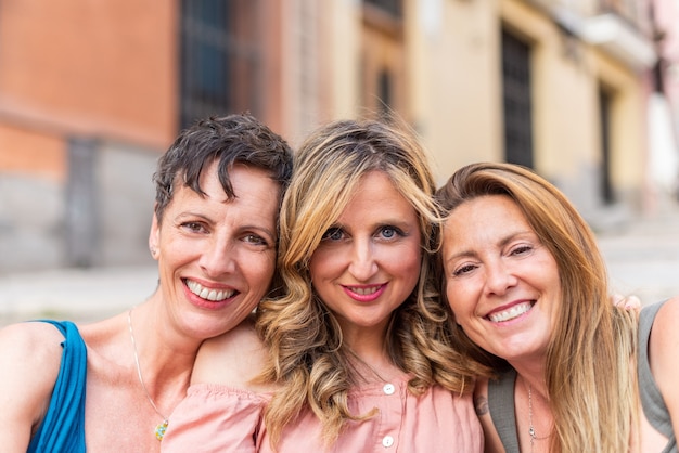 Nahaufnahme einer Gruppe von reifen Frauen, die auf der Straße in die Kamera lächeln?