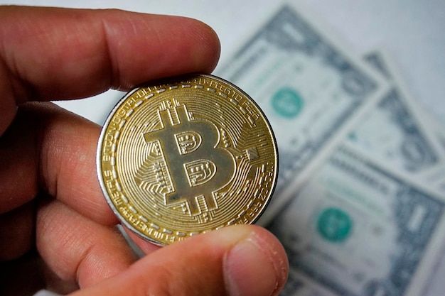 Foto nahaufnahme einer hand, die bitcoin gegen papierwährung hält