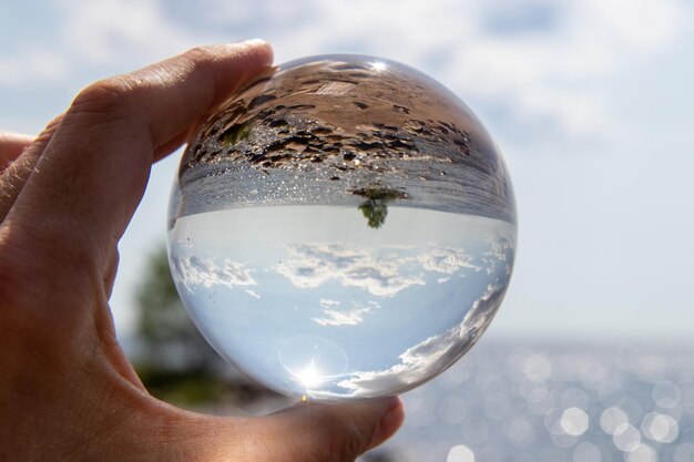 Foto nahaufnahme einer hand, die ein glas kristallkugel hält