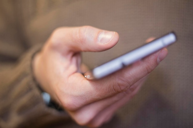 Nahaufnahme einer Hand, die ein Handy hält