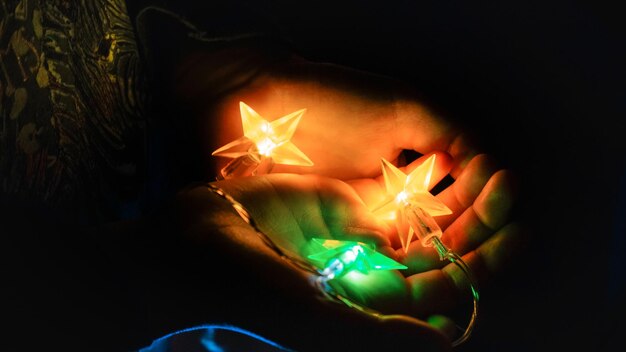 Foto nahaufnahme einer hand, die eine beleuchtete dekoration hält
