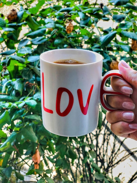 Foto nahaufnahme einer hand, die eine kaffeetasse hält.