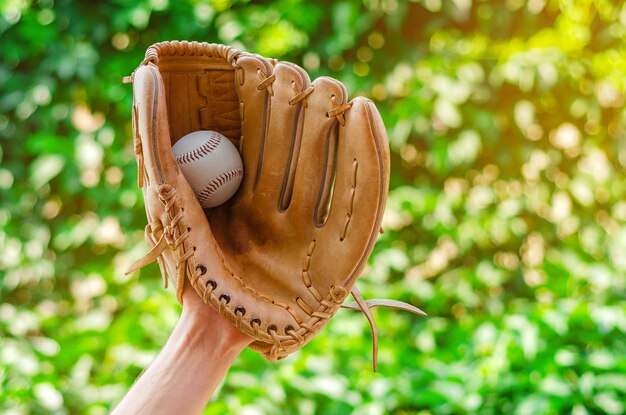 Foto nahaufnahme einer hand, die einen baseballhandschuh trägt und den ball hält