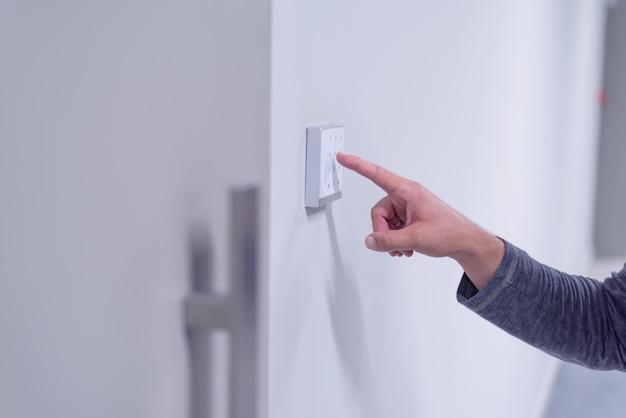 Nahaufnahme einer Hand, die einen Regenschirm an der Wand hält