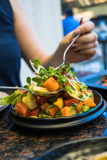 Nahaufnahme einer Hand, die Essen auf dem Tisch hält