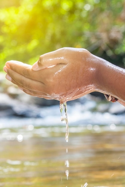 Foto nahaufnahme einer hand, die feuchtes wasser im freien hält