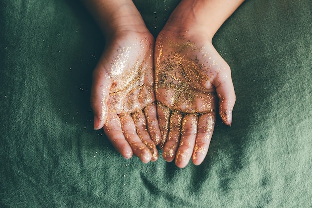 Nahaufnahme einer Hand, die mit Glitzer bedeckt ist