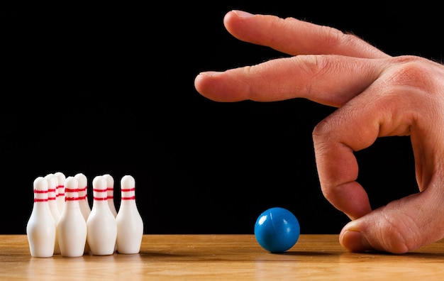 Foto nahaufnahme einer hand, die mit spielzeug gegen schwarzen hintergrund spielt