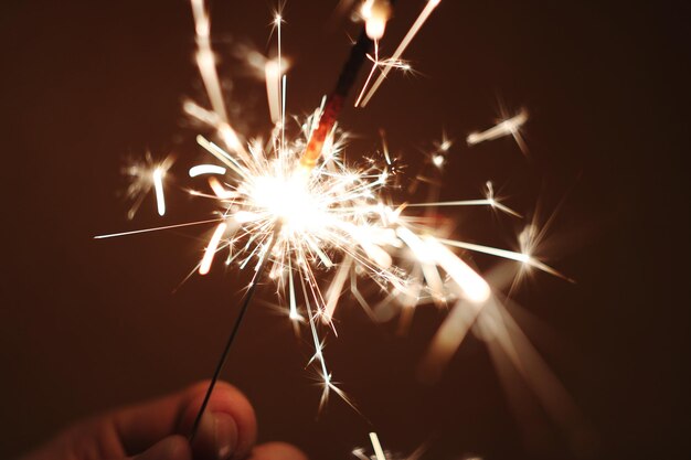 Foto nahaufnahme einer hand, die nachts eine leuchtende funkenlampe hält