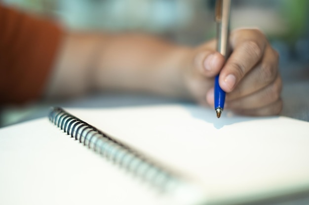 Foto nahaufnahme einer hand, die papier mit text auf dem tisch hält