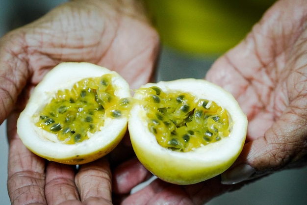 Nahaufnahme einer Hand, die Passionsfrucht hält