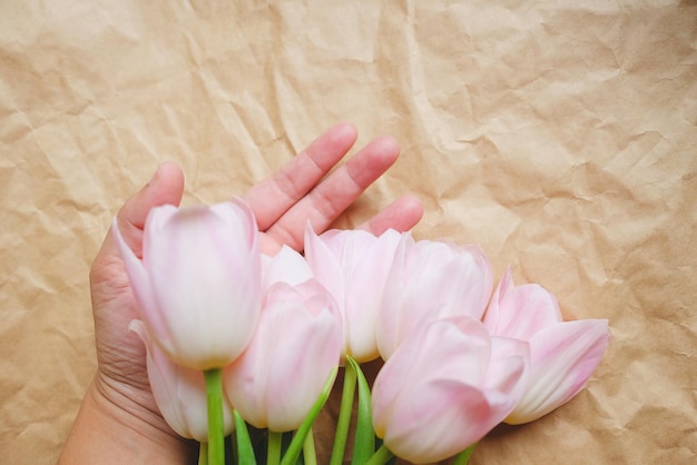 Nahaufnahme einer Hand, die rosa Rosen hält