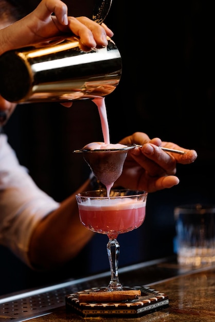Nahaufnahme einer Hand, die Wein in ein Glas gießt
