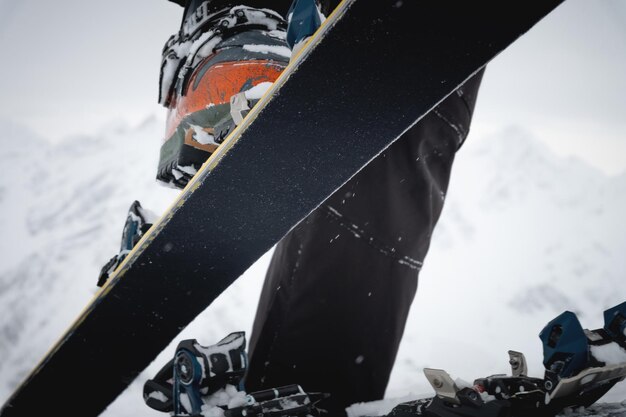 Foto nahaufnahme einer hand eines mannes, die die skis gegen den hintergrund von schnee und anziehung anpasst