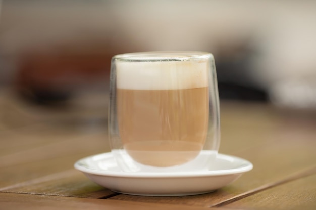 Nahaufnahme einer heißen Kaffeetasse auf einem Holztisch in einem Café und einem Restaurant