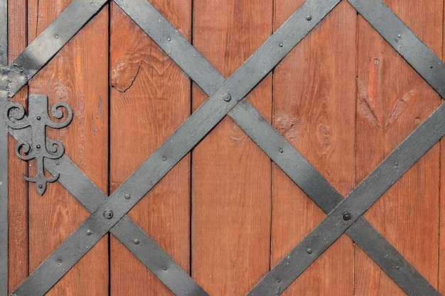 Nahaufnahme einer Holztür mit schmiedeeisernem Gitter