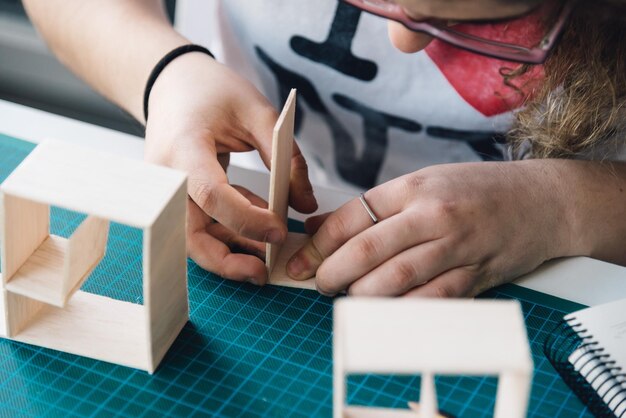 Foto nahaufnahme einer jungen frau, die mit karton auf dem tisch arbeitet