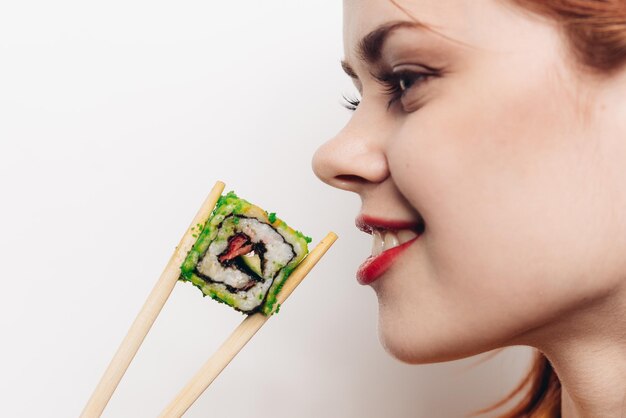 Foto nahaufnahme einer jungen frau, die vor weißem hintergrund essen isst