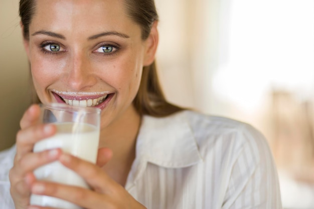 Nahaufnahme einer jungen Frau, die zu Hause Milch trinkt