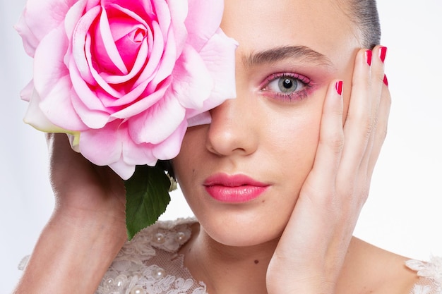 Foto nahaufnahme einer jungen frau mit einer rose auf weißem hintergrund