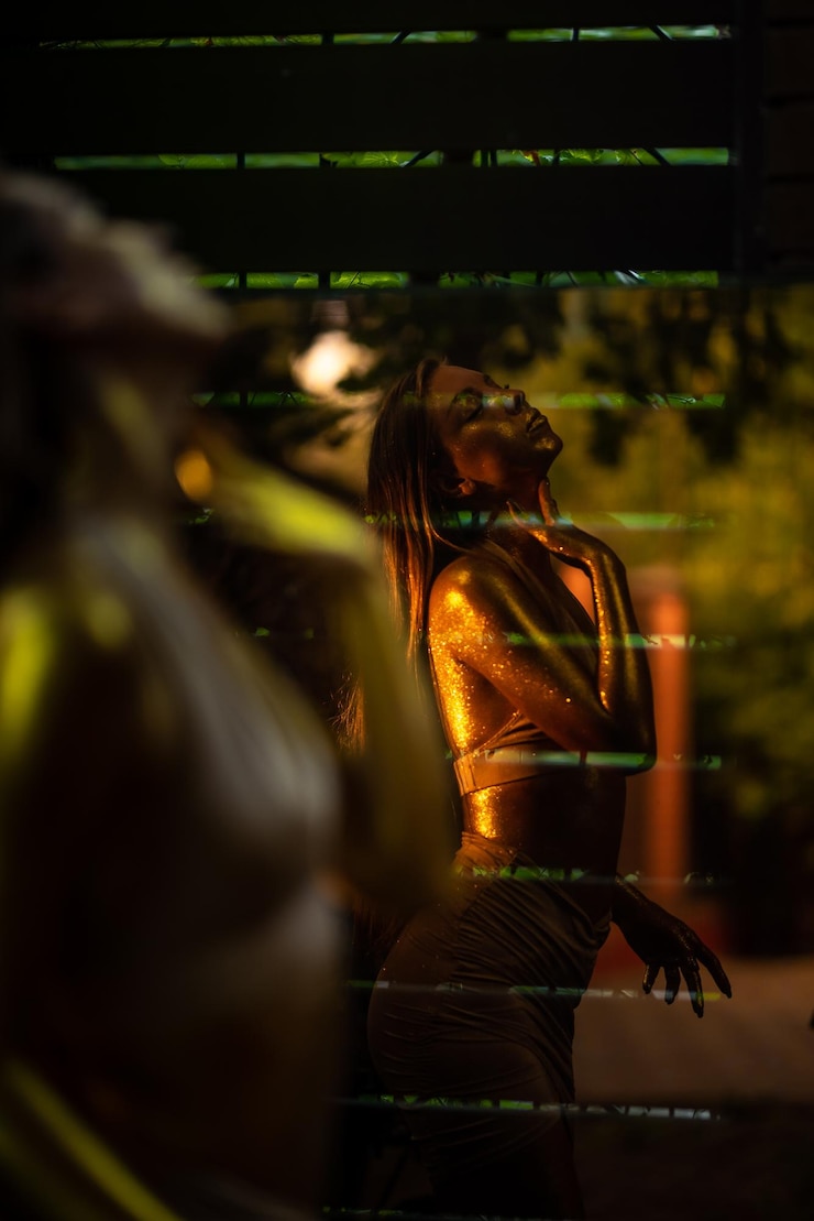 Foto nahaufnahme einer jungen frau mit goldener haut im spiegelbild