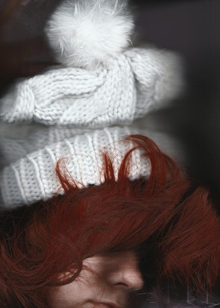 Foto nahaufnahme einer jungen frau mit roten haaren, die einen strickhut trägt