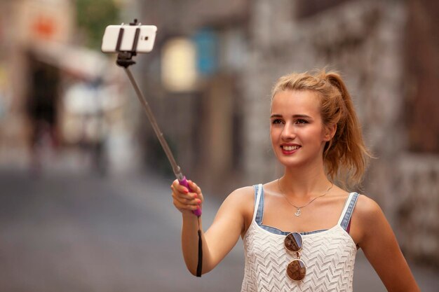 Foto nahaufnahme einer jungen frau mit selfie-stick