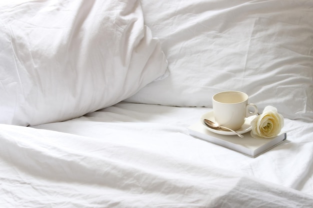 Nahaufnahme einer Kaffeetasse auf dem Bett