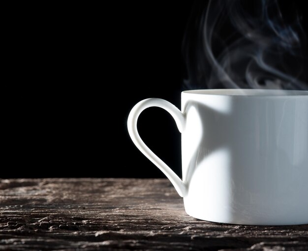 Foto nahaufnahme einer kaffeetasse auf dem tisch vor schwarzem hintergrund