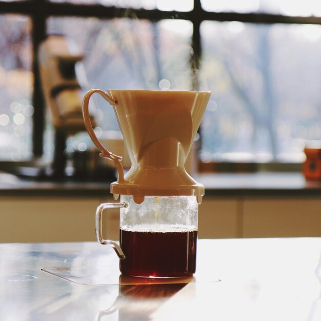 Nahaufnahme einer Kaffeetasse mit Filter auf dem Tisch