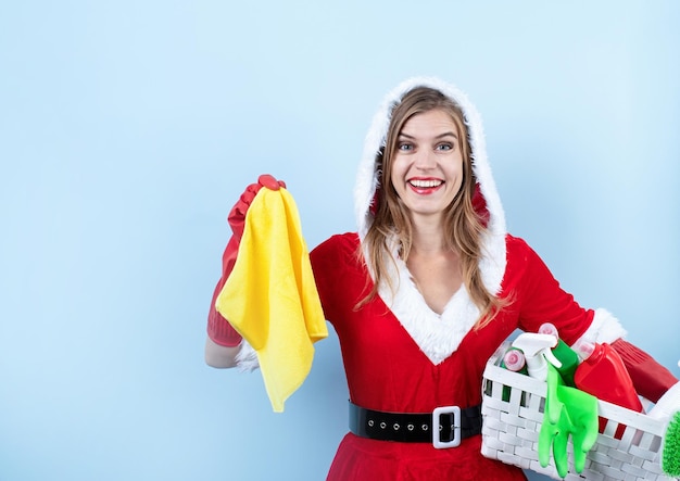 Nahaufnahme einer kaukasischen glücklichen Frau, die Weihnachtsmannkleidung trägt und Handschuhe hält, die Reinigungssprays halten